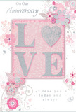 The photograph captures a softly romantic anniversary card that looks as tender as a pastel bouquet arriving at a doorstep in Sipson. At its heart, the word LOVE is beautifully raised from the card in a velvety band of glitter, each letter outlined with delicate sparkle. The letter O is transformed into a shimmering silver heart, textured so finely that it appears almost like pressed metal or densely layered glitter, inviting a gentle touch. Surrounding this central word is a halo of delicate flowers in blush pink, mauve, and ivory, their petals painted with a watercolour softness and traced with slender outlines that give each bloom a graceful, drifting quality, as though resting atop tissue paper in a florist's gift box. Wisps of vines, tiny petals, swirling flourishes, and subtle butterflies weave through the design, adding a sense of quiet motion and whimsy, similar to watching petals flutter in a light breeze across Sipson's gardens. The background is a calm, powdery pink, merging softly into pale grey and white highlights, which lend the entire card an intimate, almost whispered feeling. In elegant, understated script, the phrases On Our Anniversary and I love you today and always appear, placed thoughtfully around the floral elements so that they feel part of the artwork rather than separate text. The composition evokes an English spring garden in full bloom, yet distilled into a single keepsake, perfect for accompanying anniversary flowers delivered to homes and hotels around Sipson and the nearby Heathrow area, where every detail speaks of shared memories and enduring romance.
